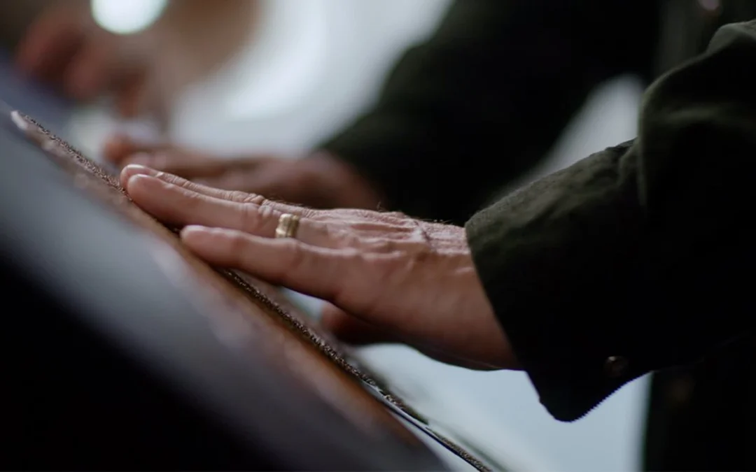 In the middle is a hand. The fingers of the hand are on a picture made tactile.